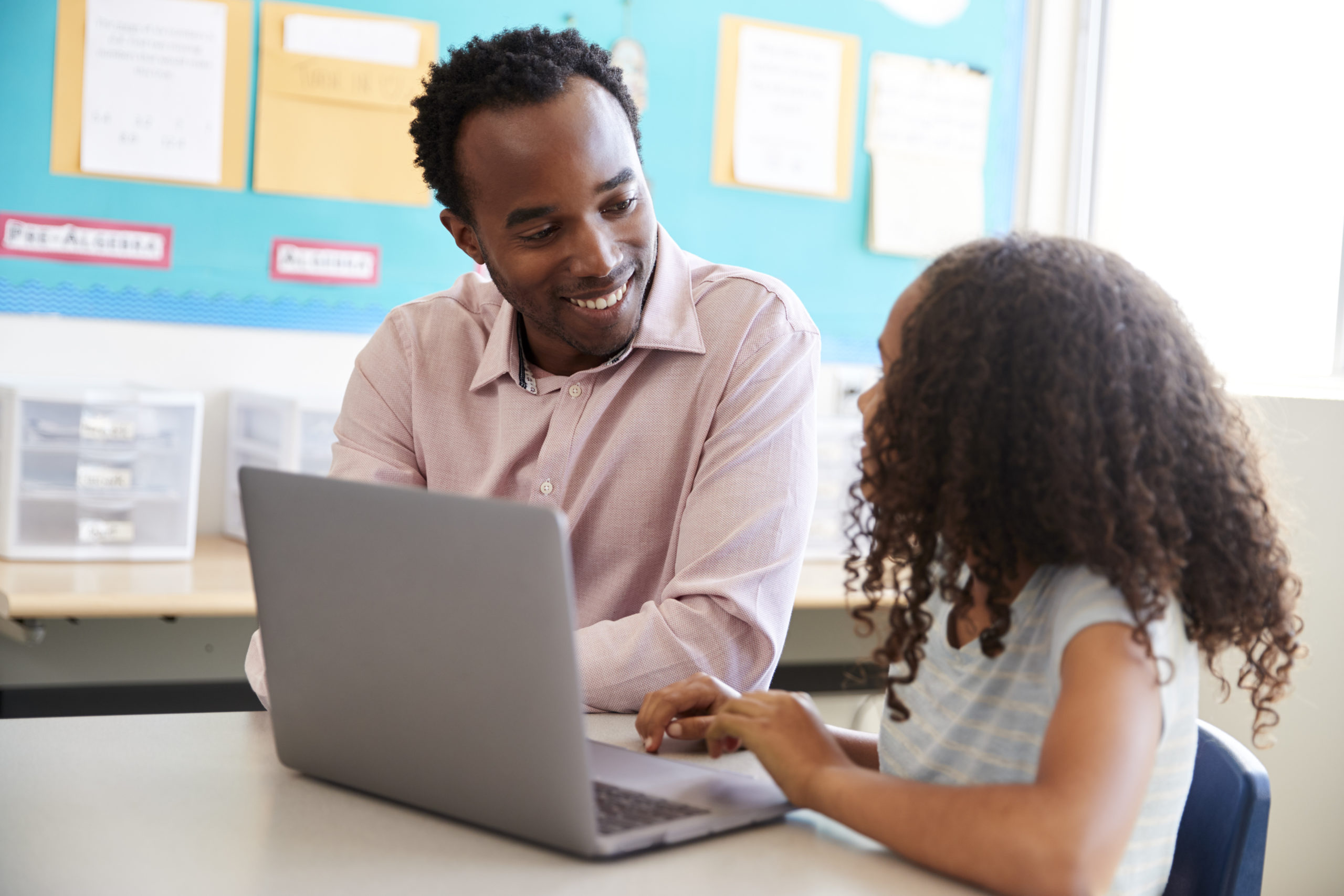 Two elementary aged boys learning digital literacy skills on computer in school library