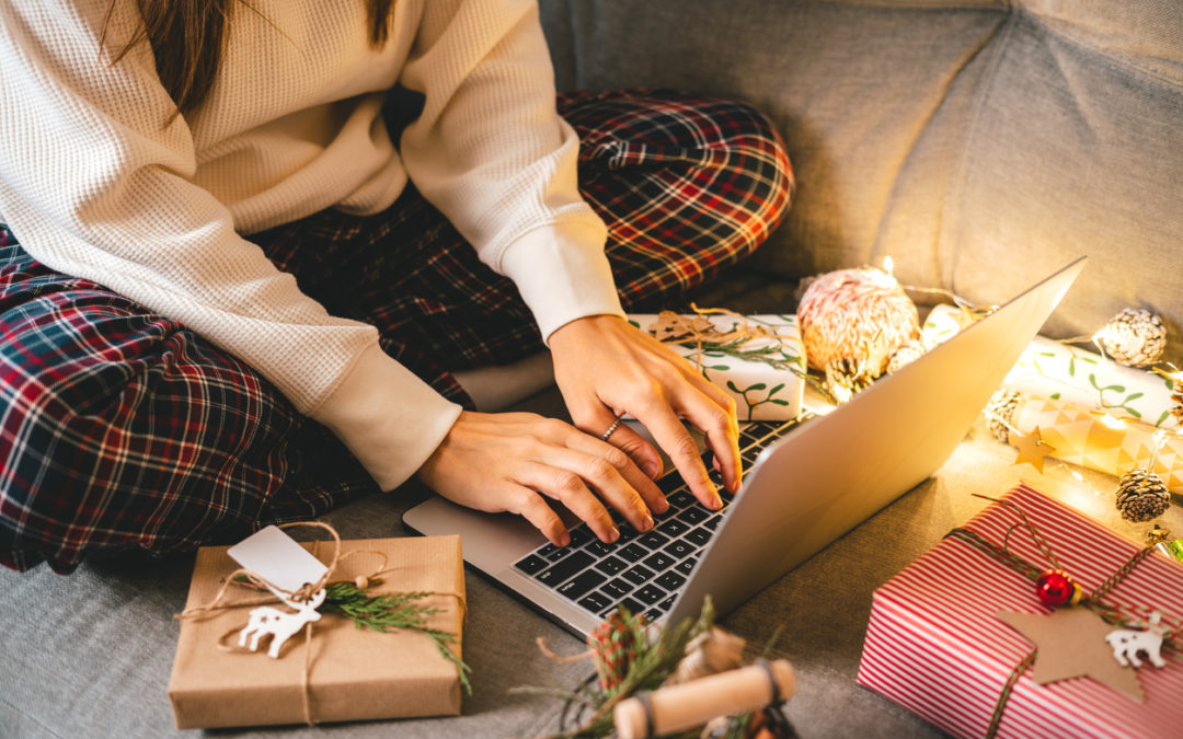 Female student staying safe online on computer surrounded by Christmas presents and holiday lights