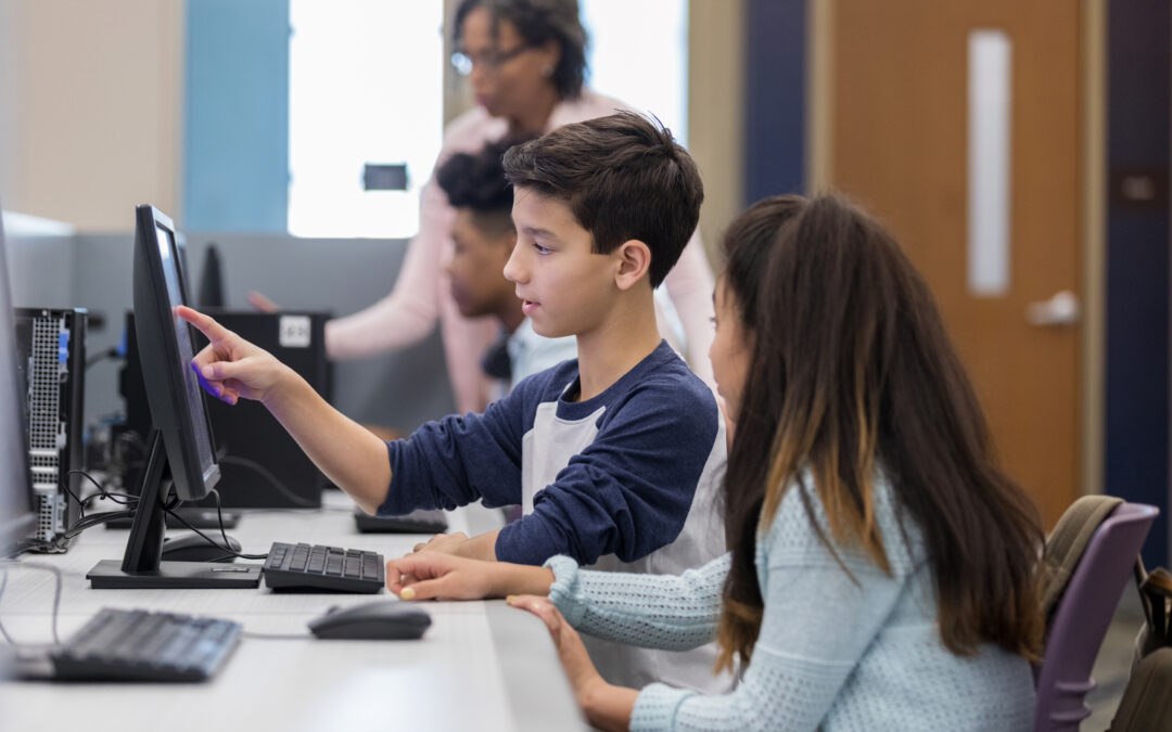 Middle school students practicing digital literacy skills in computer classroom