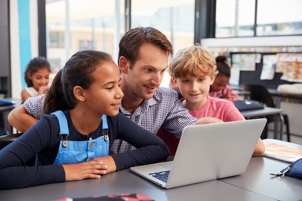 Two elementary aged boys learning digital literacy skills on computer in school library
