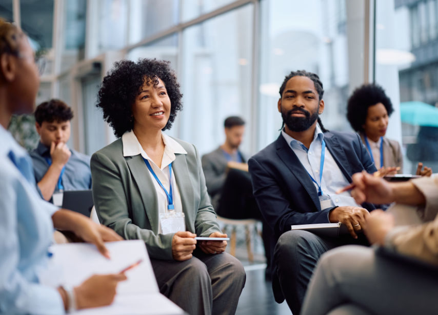 Smiling teacher assisting a student at a computer in a classroom setting