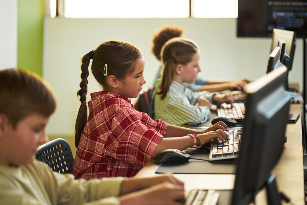 Male teacher with elementary-age students surrounding him as he shows them how to use AI effectively on a tablet